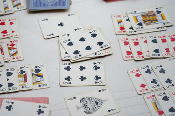 Scattered playing cards spread across a light surface provide excellent copy space for game and leisure themes.