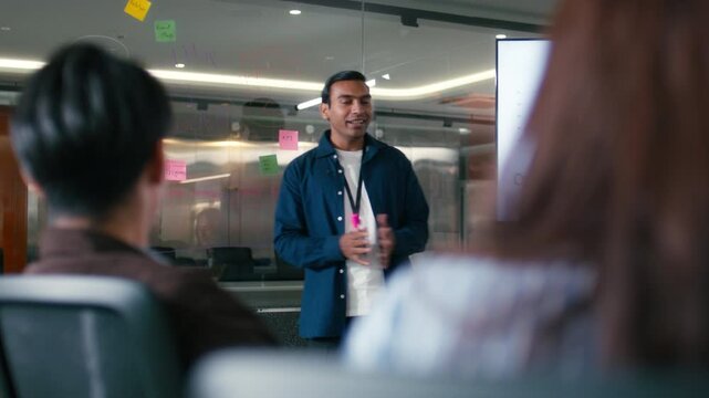 Confident Indian Businessman presenting ideas discussing strategy analysis financial data charts and graphs report on screen monitor with colleagues in boardroom office. Corporate Business meeting. - Powered by Adobe