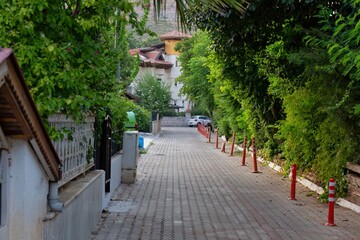 Obraz premium A brick road leads into the distance, lined by trees in Icmeler - Marmaris - Mugla - Turkey