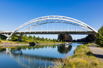 Obraz premium Modern Arch Bridge Over Serene Canal Bridge crossed Zuid-Willemsvaart in Beek-Bree, Belgium 