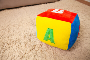 Children's plush dice with the letter A written on them. Letter concept.