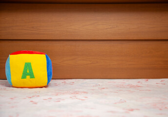 Children's plush dice with the letter A written on them. Letter concept.