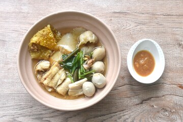 boiled dory fish and fishball with bean sprout topping crispy dumpling in soup on bowl dipping spicy chili soy paste sauce