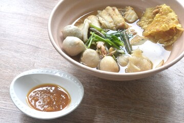 boiled dory fish and fishball with bean sprout topping crispy dumpling in soup on bowl dipping spicy chili soy paste sauce