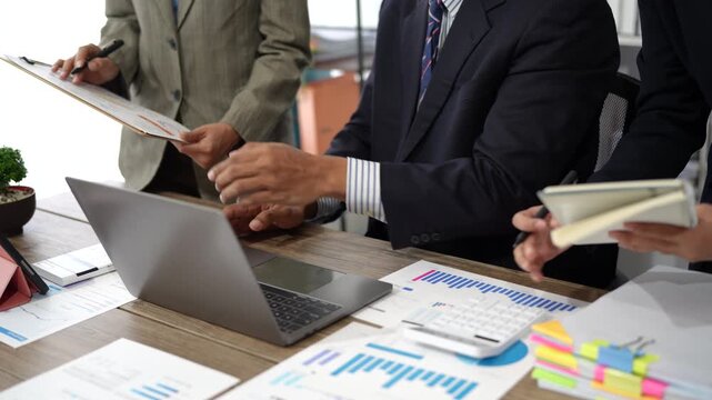 Close-up asia business people meeting plan analysis statistics brainstorm and header of team hold tablet pointing graph chart and employee take note. Finance strategy statistics success concept.
