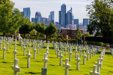 Tombstones at the Suresnes American Cemetery in Suresnes with the highrises of  La Defense in the background