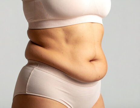 Close-up of woman body with belly fat folds. Concept image for weight loss, health, fitness, and body care