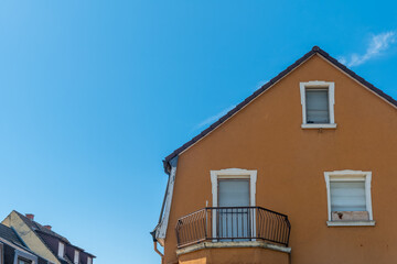 Bright blue sky contrasts with a warm, earthy facade of a tranquil home in a peaceful neighborhood during midday