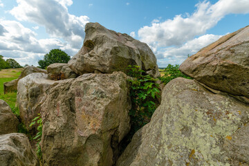 Die mächtigen Felsen des Großsteingrabs auf dem St. Annenberg bei Helmstedt zeigen ihre uralte Struktur mit Moos und Flechten unter blauem Himmel.