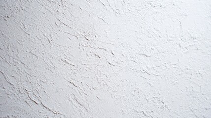 A textured wall with a rough finish, featuring visible patterns and irregularities in a light neutral tone,