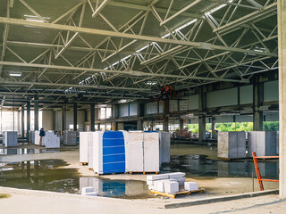 Inside a warehouse under construction, revealing structural elements and building materials.