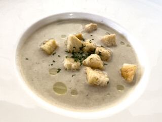 Creamy Mushroom Soup with Croutons on a White Plate