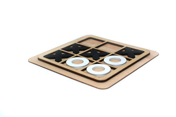 A wooden game set of noughts and crosses on a black background, tic-tac-toe. Tic tac toe game. isolated on white background