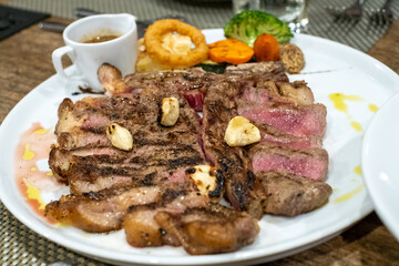 Grilled Ribeye Steak with Vegetables and Sauce on Plate