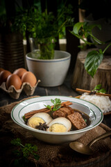 Brown boiled eggs with condiments in a bowl (braised eggs), rich broth, fragrant with herbs, a home-cooked Asian dish.