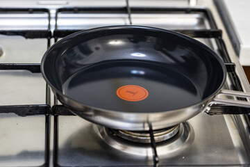 Close-up of a Tefal Pan on a Gas Stove with Blue Flame