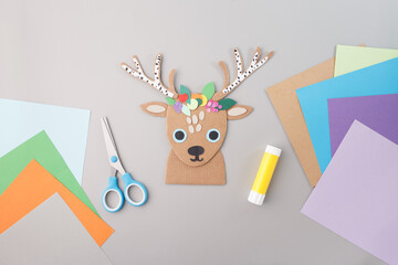 Paper reindeer craft with floral antlers on colorful background, ideal for holiday marketing, DIY blogs, kids activities, school projects, handmade gift promotions,