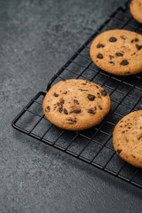 Freshly baked chocolate chip cookies cooling on a wire rack in a kitchen