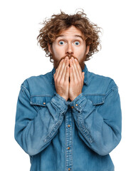 A young man with an expressive face and curly brown hair covers his mouth with his hands, looking surprised