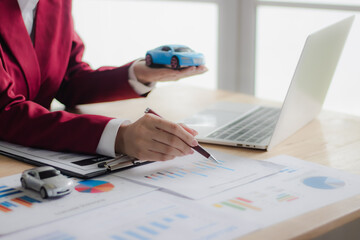 Asian businesswoman in suit smiling while advising clients on insurance policies, trusts, finances and successful contract agreements.