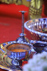Traditional Indian puja thali with diya, kumkum, rice, and offerings for rituals.
