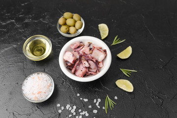 Octopus with olives, oil and salt on black background for gourmet ingredient or rustic cooking concept