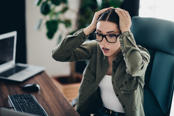 Professional computer programmer shocked by computer error while working online in a home office workspace