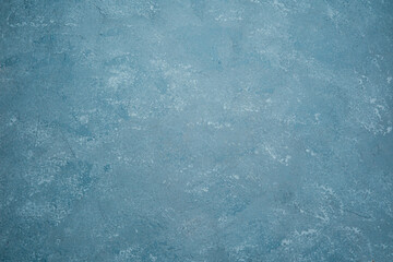 Blue wall with rough plaster texture and mottled grunge surface