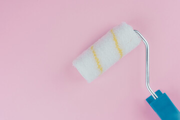Obraz premium Single blue handled roller on pink background for minimalism and painting concept