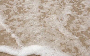 texture of a white sand Sea waves foam on the sand on the shore