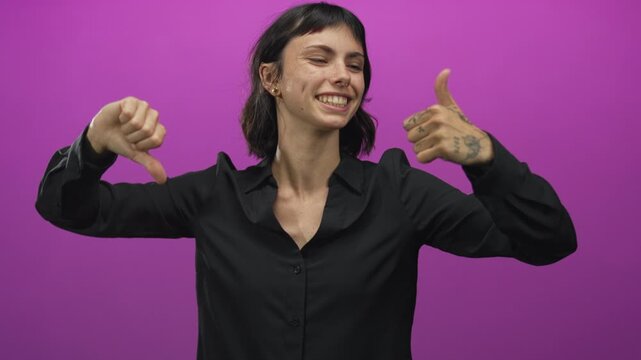 Woman wearing black shirt holds thumbs up and thumbs down gesture in purple studio; indecision dilemma.