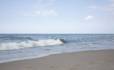 blue-gray Baltic Sea with small white waves against a background of a gently blue sky with small clouds, beautiful sea landscape