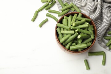 Pieces of fresh pea pods, bowl and napkin on white table, flat lay. Space for text