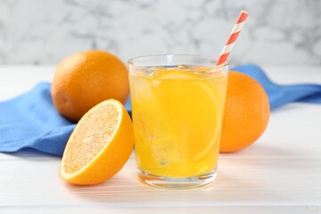 Refreshing soda water with orange slice in glass and fresh fruits on white wooden table, closeup