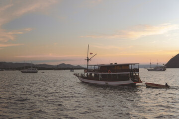 Fototapeta premium Beautiful scenery of a boat sailing in Labuan Bajo ocean with mountain island on the background.
