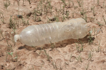 A plastic bottle lying on the ground, Plastic pollution, Plastic environmental impact
