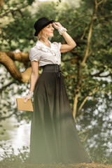 Fototapeta premium Gorgeous Victorian Blonde Woman with book in the Forest.Vintage