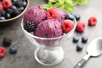 Delicious sorbet with fresh berries and mint in dessert bowl on grey textured table, closeup