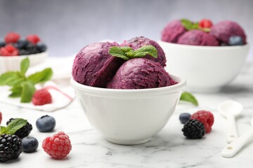 Delicious sorbet in bowl, fresh berries and mint on white marble table against grey background, closeup