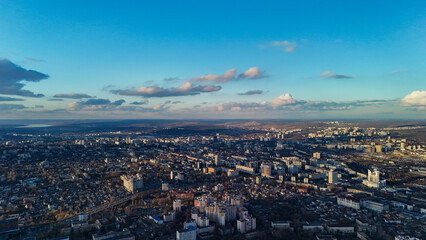 Aerial cityscape with sun rays breaking through clouds at sunset