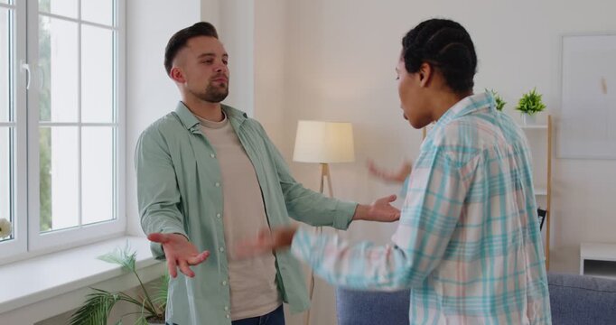 Young couple home conflict, man and a woman engaging in argument, gesturing expressively, upset, tense and confrontational talk, serious disagreement or argument, unacceptable differences in interests