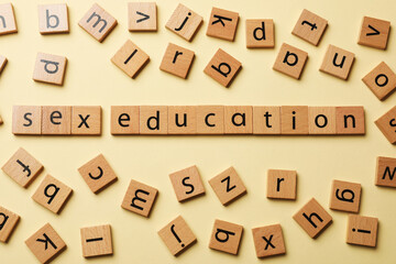 Words Sex Education made of wooden squares with letters on beige background, flat lay