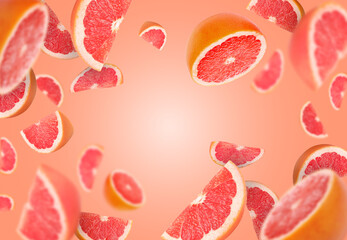 Fresh grapefruits swirling in air against coral background