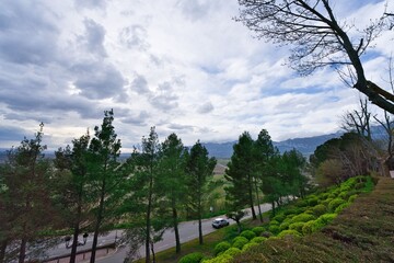 Obraz premium Access road to the town of Laguardia, Basque Country, with its green gardens and the mountain range in the background.