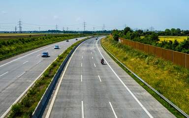 Fototapeta premium Summer landscape with highway, power lines and blue sky in background
