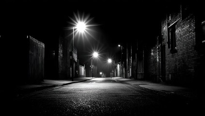 A black and white street at night.  Urban alleyway