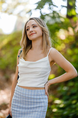 Fototapeta premium Young woman poses confidently outdoors in a stylish outfit during a sunny day