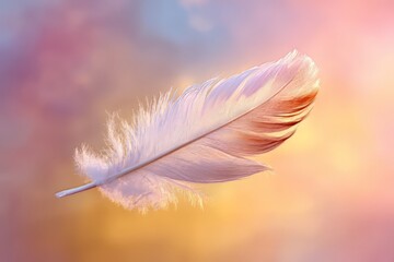 Naklejka premium A single delicate white feather with hints of pink and gold, floating against a soft, colorful bokeh background