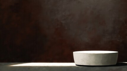 Empty light gray oval pedestal against a dark brown textured wall.