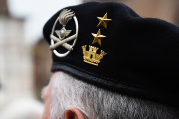 Close-up of Italian military veteran&rsquo;s beret with medals and insignia during public ceremony. Symbol of honor, rank, and military heritage. A portrait of identity through uniform detail.